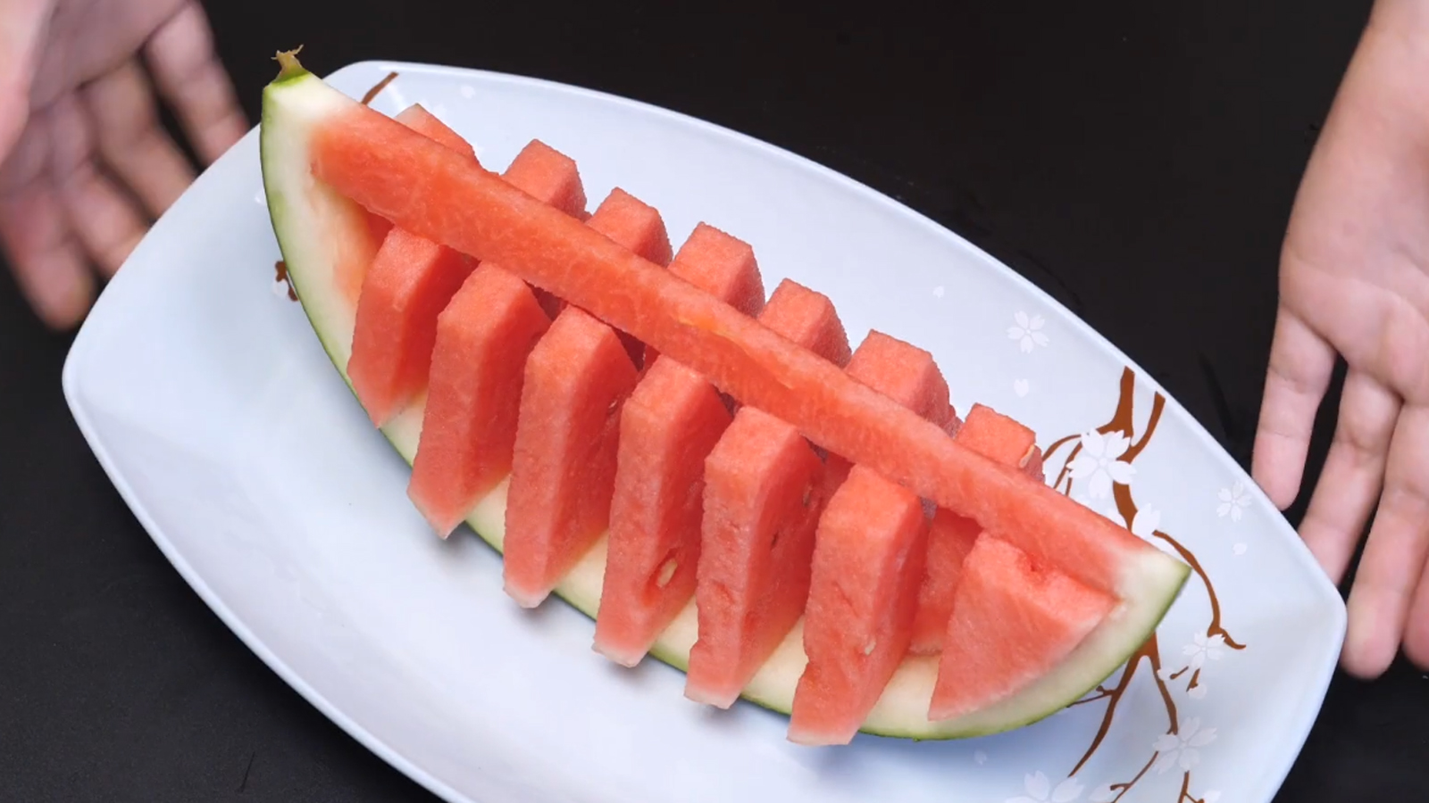 然后把瓜皮切成下图这个样子,摆盘,吃的时候拿着瓜皮,这样吃西瓜是不