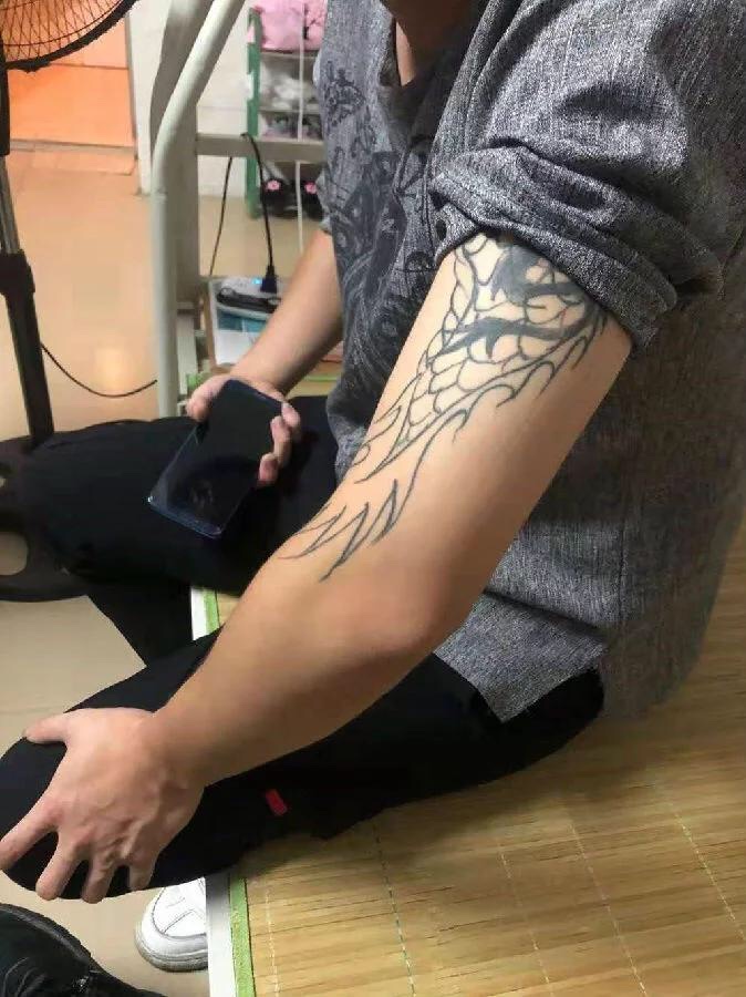 肱二头肌部位纹了一条龙,面积比较大,但穿衣服能够盖住手臂上的纹身