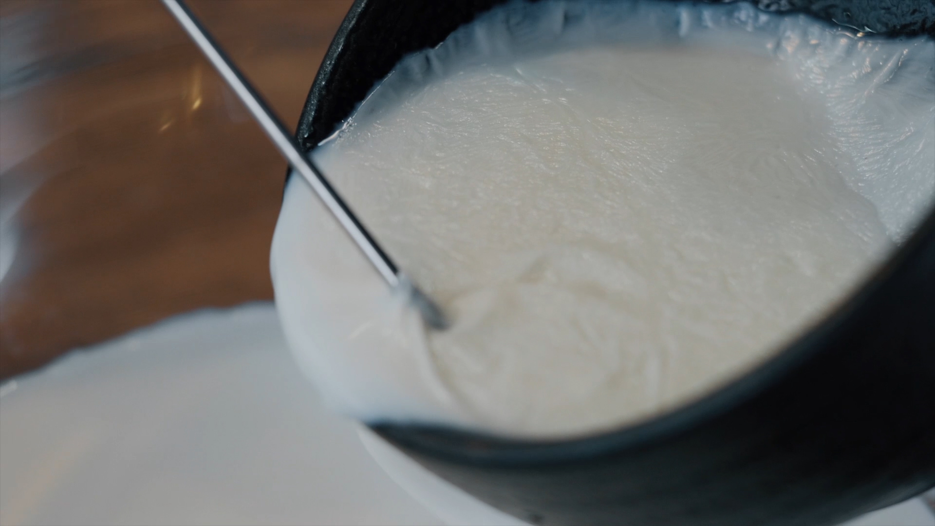 5,从挑起奶皮处,把牛奶缓缓倒出,留一点在碗底.