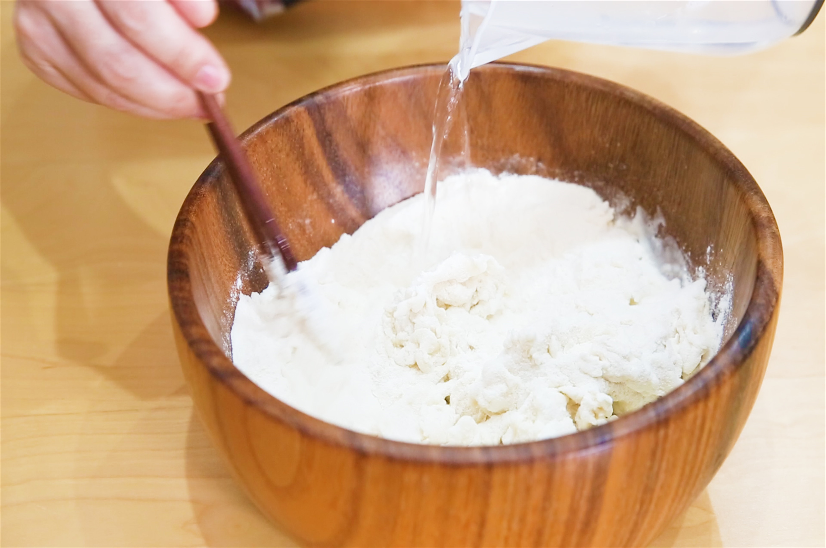 300克面粉加入3克盐,加入180克开水和面,搅拌成絮状